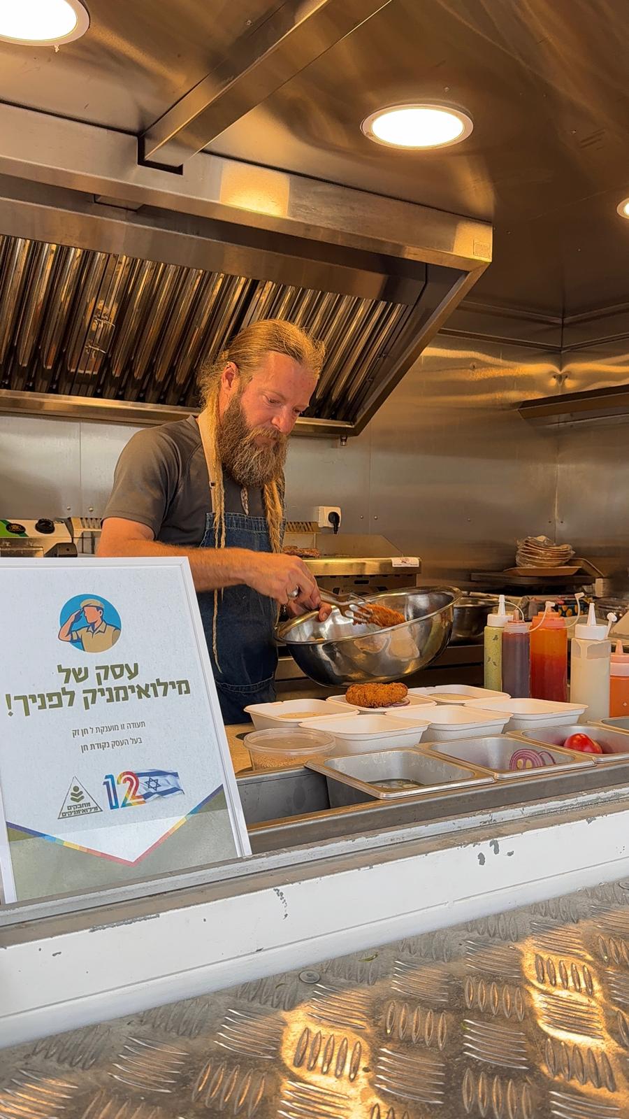 חן זק עובד בעגלה, לצידו שלט: עסק של מילואימניק לפניך